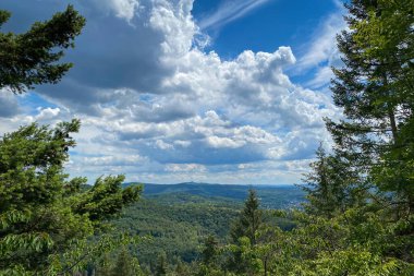 Almanya 'daki Siebengebirge dağ sırasının panoramik görüntüsü bulutlu mavi gökyüzüne karşı.