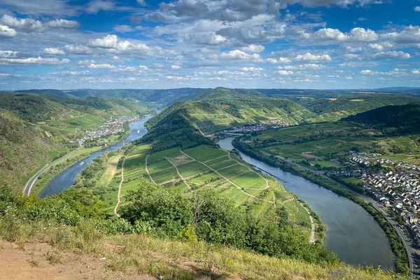 Landscape and scenic view from Calmont hiking trail to Moselle loop (germ. Moselschleife) and the villages of Ediger-Eller, Neef and Bremm (left to right), Germany against blue sky