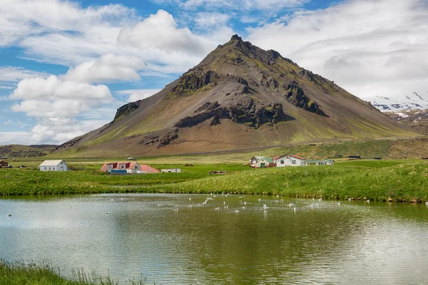 Paisaje escénico con pueblo y volcán en Islandia . — Foto de Stock