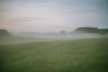 Yuvarlanan tepelerin üzerinde sabah sisi vardı.