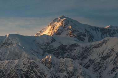 Alaska 'nın iç kesimlerinde, Denali' nin hava yoluyla görüldüğü kar üzerinde gün batımı parlıyor.
