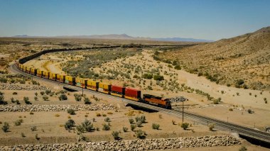Yük treni konteynırları çölden geçiriyor.