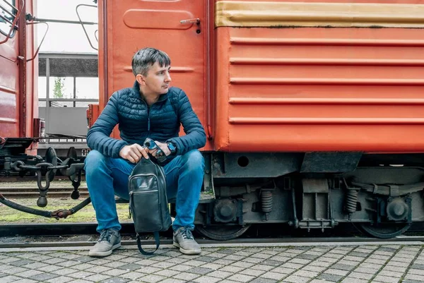 男人坐在一辆旧火车的大篷车上 向右转 — 图库照片