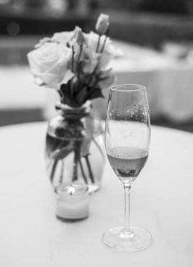 Çiçeklerle yapılmış bir süs ve bir bardak şampanya.