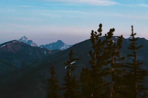 落日的时候 在远处看到的浓密的雪覆盖着山峰 — 图库照片