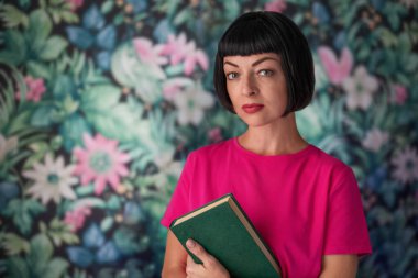 A middle-aged woman holds a book in her hands.