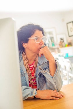 Latin woman thinking at her desk