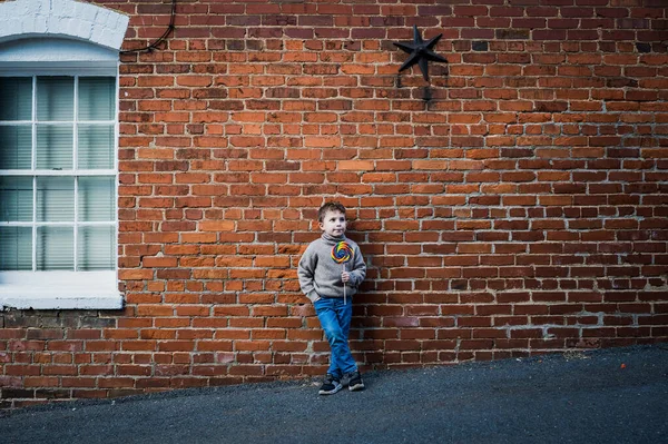 Little Boy Big Lollipop Leaning Old Brick Wall — Fotografia de Stock