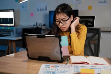 ofiste dizüstü bilgisayarda çalışan genç kadın