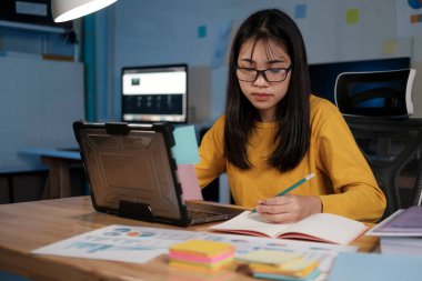 ofiste dizüstü bilgisayarda çalışan genç kadın