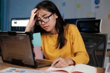 ofiste dizüstü bilgisayarda çalışan genç kadın