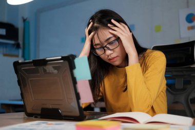 ofiste dizüstü bilgisayarda çalışan genç kadın