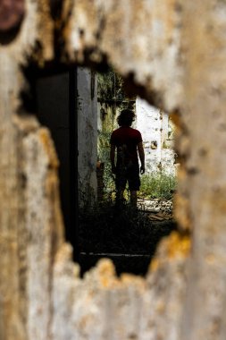 Sırtı dönük genç bir çocuk ahşap bir kapı deliğinden vuruldu.