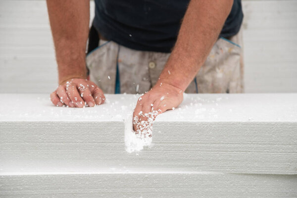 Worker cleaning cut in styrofoam