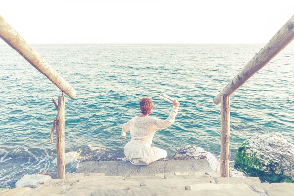 Mulher Meia Idade Jogando Uma Garrafa Mensagem Mar — Fotografia de Stock