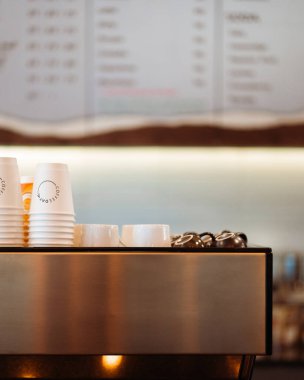 Kahve makinası kahve fincanlarıyla bir masanın üzerinde duruyor.