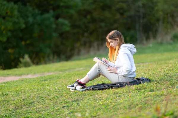 Una Joven Está Sentada Parque Escribiendo Cuaderno —  Fotos de Stock