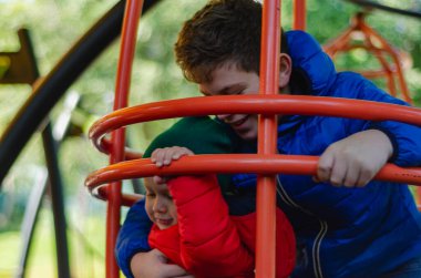 Kardeşler oyun alanında oynuyor, boş alan.