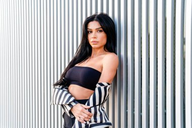 Zarif ve çekici bir kadın kameraya bakıyor.