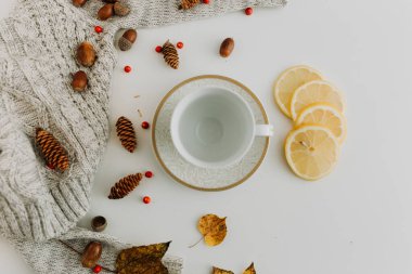 Beyaz üzerine beyaz, beyaz, meşe palamudu ve limon dolu boş beyaz ve altın çay bardağı.