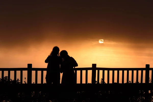 Silhoutte Två Unga Vuxna Kvinnor Som Står Solnedgången — Stockfoto