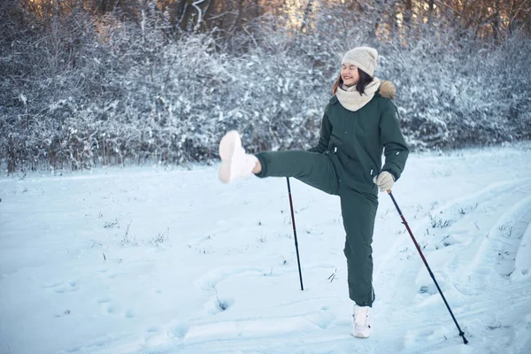 若いです笑う女性で冬全体に歩くポールリフト脚 — ストック写真