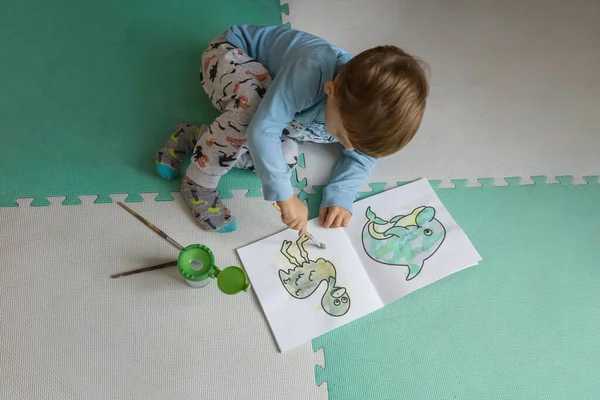 小男孩儿用画笔在水本上涂色 — 图库照片