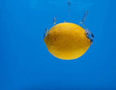 Mavi arka planda su kabarcıkları olan limon