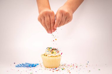 Doğum günü pastasını süslemek için çocuk eli.