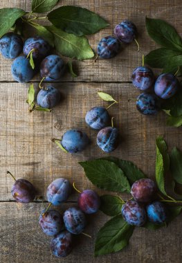 Tahta zemine serpiştirilmiş taze erik manzarası.