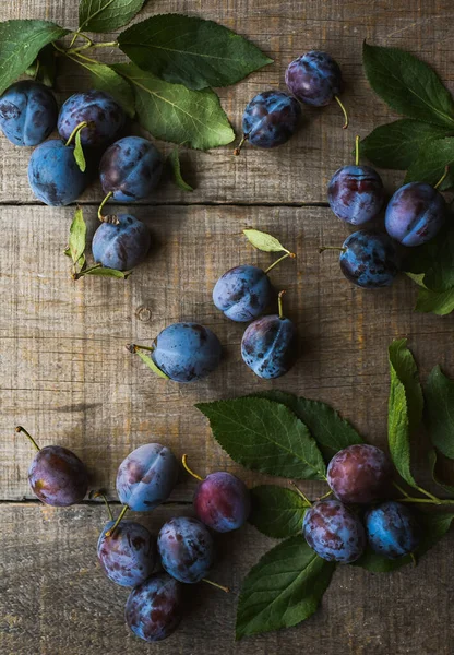 Tahta zemine serpiştirilmiş taze erik manzarası.