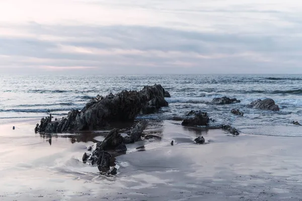 曇り空の海の真ん中の岩 — ストック写真