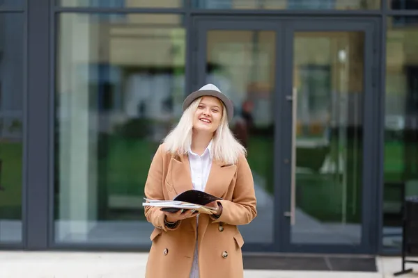 Giovane Donna Bionda Sorridente Cappotto Libri Smartphone Mano — Foto Stock