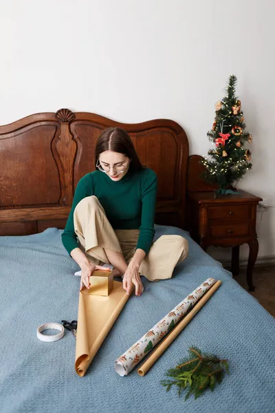 Ung Kvinna Packar Julklapp När Sitter Sängen Hemma — Stockfoto