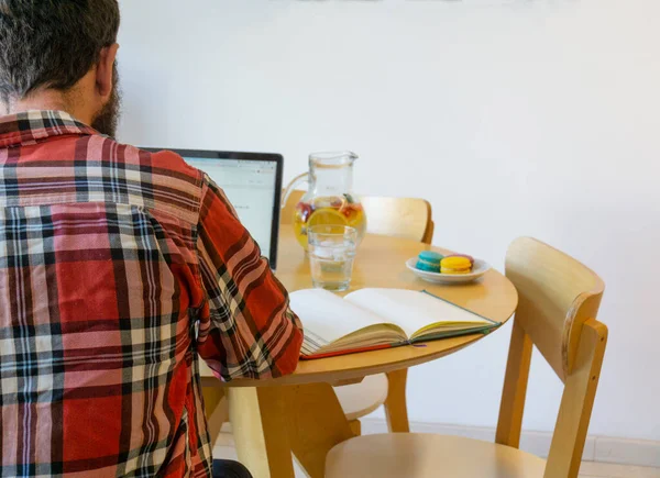 Yemek Masasında Dizüstü Bilgisayarıyla Çalışan Bir Adamın Arka Görüntüsü — Stok fotoğraf