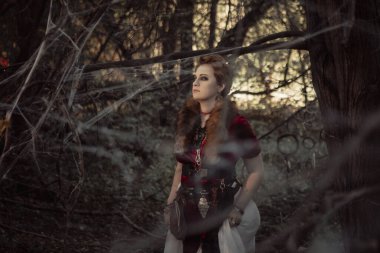 Kısa saçlı cadı vahşi doğanın arka planına karşı.