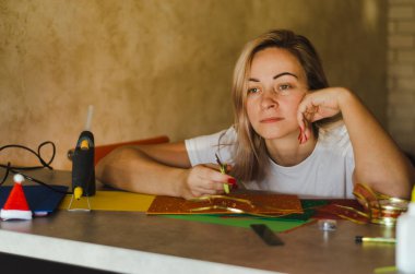 Beyaz kadın dekorasyon için ne yaratacağını düşünüyor.