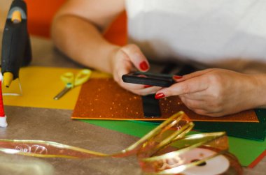Dekorasyon araçlarının arka planına karşı elde telefon