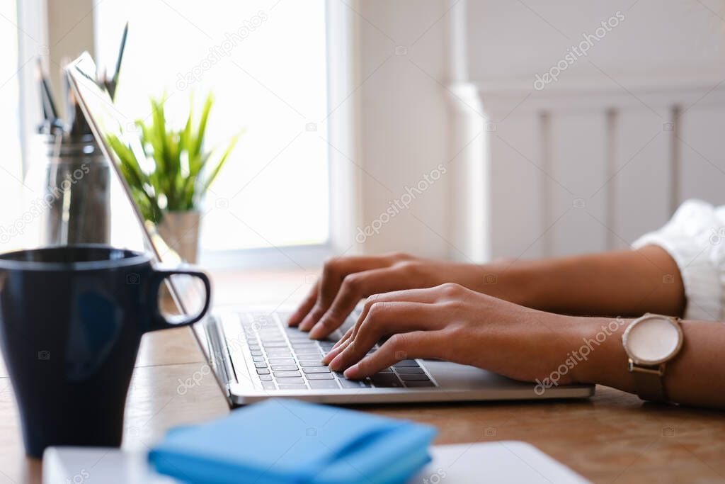 Closeup hand of woman working laptop computer.
