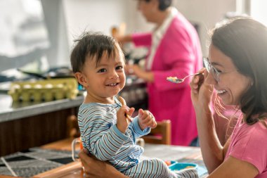 Happy Latin family sharing time at the kitchen during breakfast