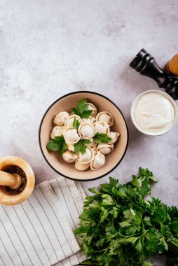 Etli hamur tatlısı, hafif taşlı arka planda otlar.