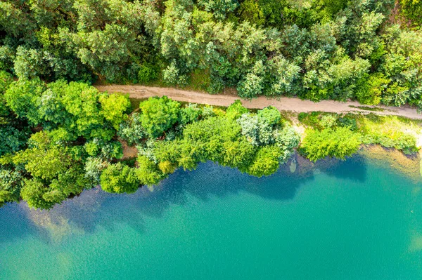Yeşil ormandan geçen kırsal yolun havadan görünüşü 