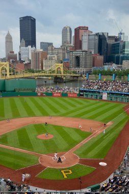 Pittsburgh Korsanları, arka planda Pittsburgh şehir merkezinde PNC Park 'ta bir oyun oynuyor.