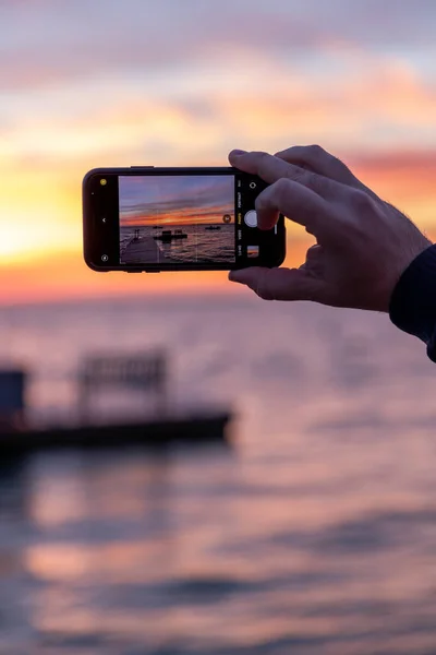 Hand Houden Van Een Smartphone Met Zonsondergang Hemel Achtergrond — Stockfoto