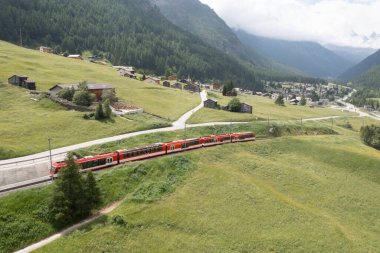 Kırmızı tren vadide, havadan görünüyor.