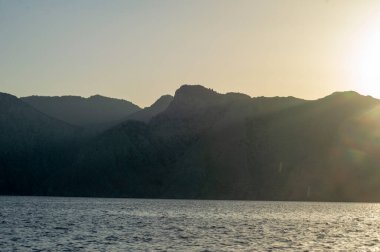 Ege Denizi 'ndeki Yunan adaları üzerinde batmış bir deniz manzarası. Tepelerin silueti