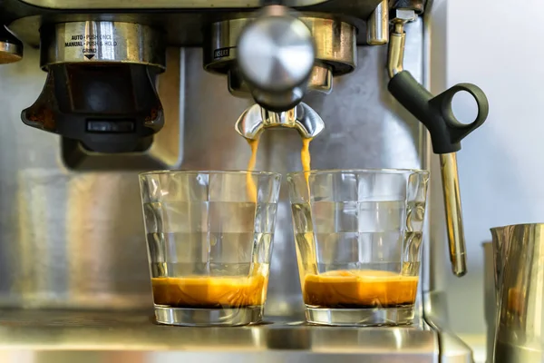 Espresso kahve makinesinin tutacağından iki bardağa akıyor.