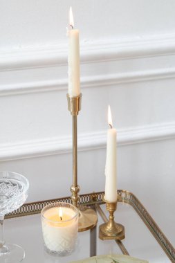 Altın şamdanlar ve cam tepside mumlar.