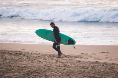 Sahilde sörfçü sudan döndü.