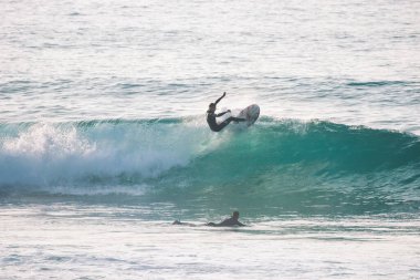 Güneşli bir günde mavi bir dalgada sörfçü